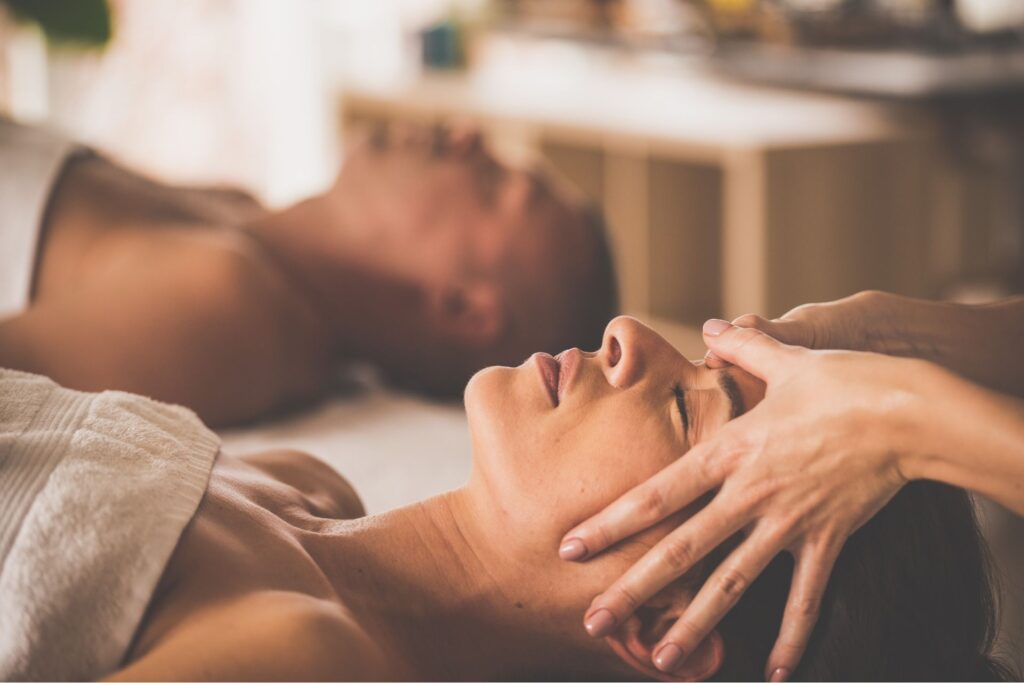 donna su un lettino che riceve un massaggio rilassante al viso